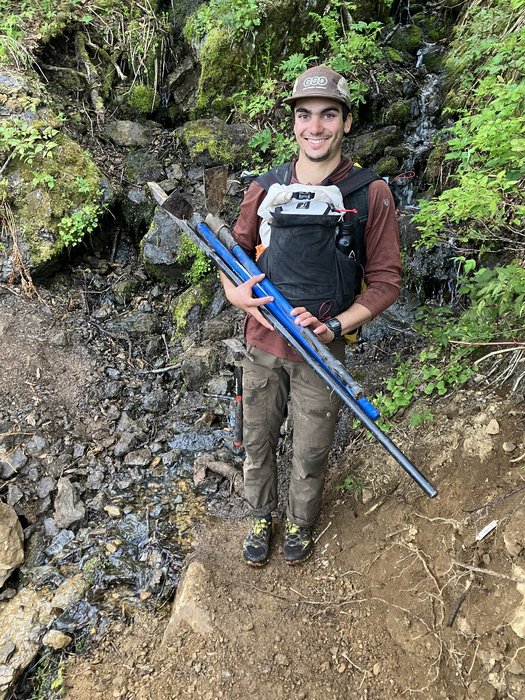 Krishna holding trail tools, an average day as Hig's intern.