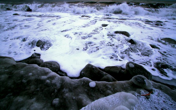 Atop an ice berm looking down at the wave action.