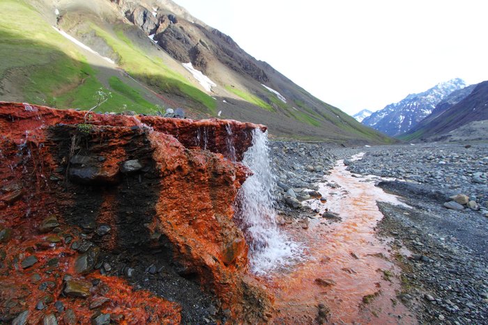Natural weathering of sulfide rocks feeds acid and iron into this spring.