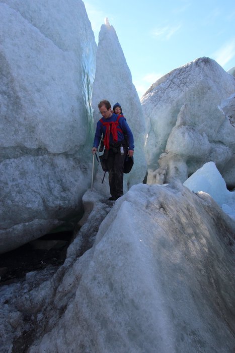 Toddler Katmai on his back, Hig picks his way through stranded icebergs on the shore of Oily Lake, near the Samovar Hills.