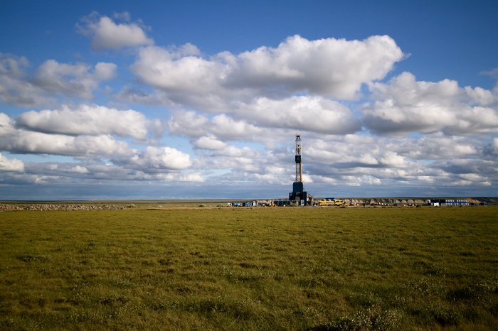 Tall industrial structures juxtapose the flat plain.