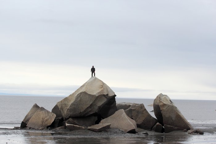 Hig stands on top of a giant erratic boulder.