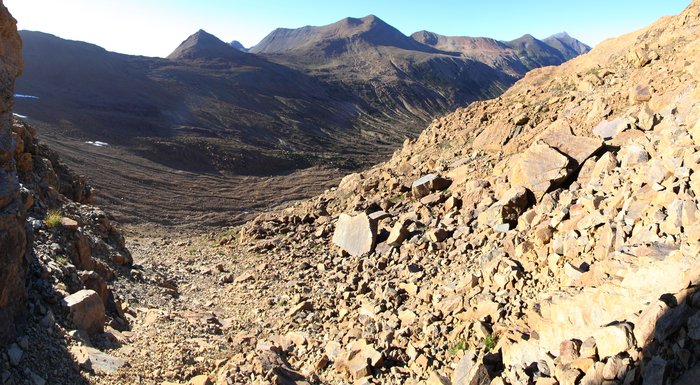 The '<a href="http://en.wikipedia.org/wiki/Serpentine_soil">serpentine soil</a>' at Red Mountain forms from weathering olivine.  Though it appears barren, several species of plants are found here but nowhere else nearby.