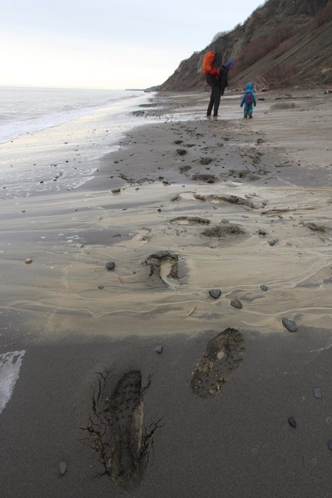 Mud flows down the beach the day after rain.