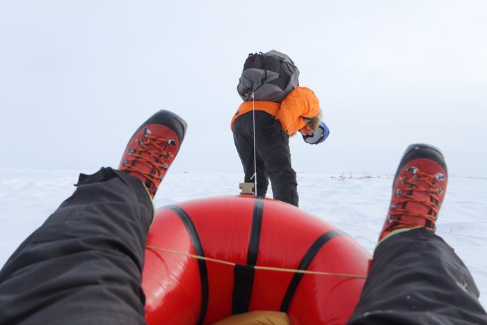 Hig pulls Erin in a packraft sled
