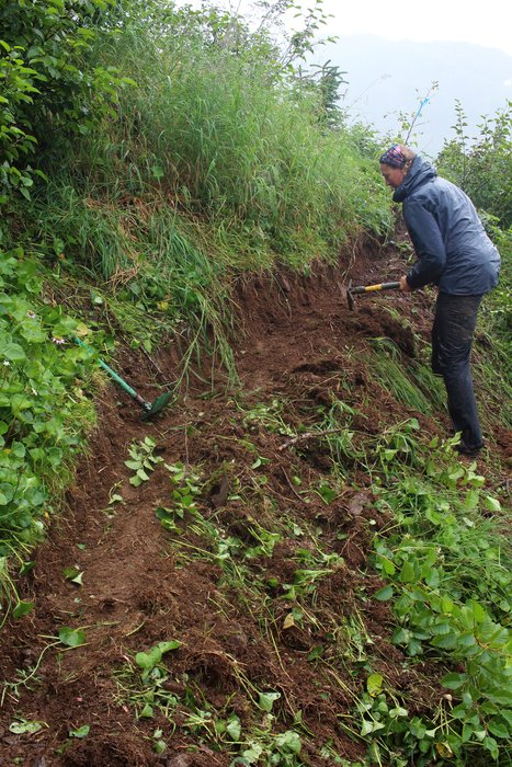 Kari Hendrich cuts tread along a steep climb out of a gully.