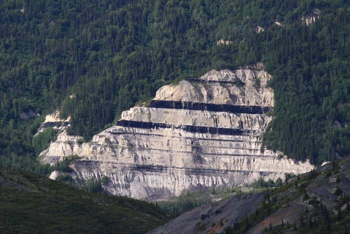 A sandstone bluff along Lignite Creek reveals the huge coal seams that have been mined here for decades.