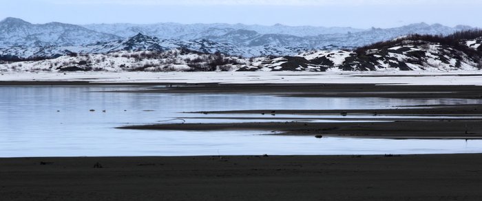 The icy snowy vista fails to evoke the tremendous melting that has resculpted the dirty vegetated glacier in the distance.