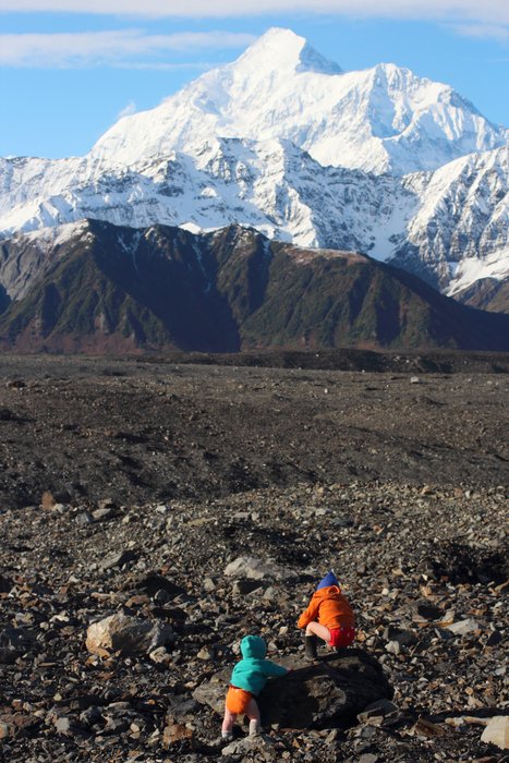 The kids pose in just their diapers on an unusually warm day, standing on the graveled ice of Malaspina Glacier, Mt. St. Elias in the background.