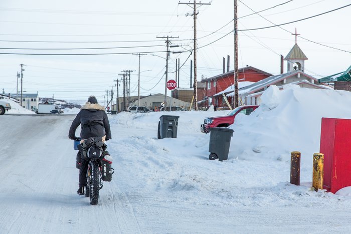 Kim rides into Kotzebue. Cars and stop signs are a stark contrast to the world we'd just ridden from 