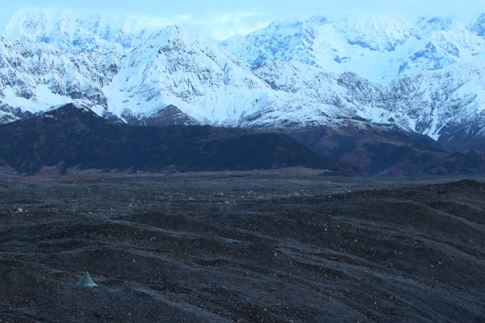 Our tent vanishes into a vast lanscape of rocky ice and snowy mountains.