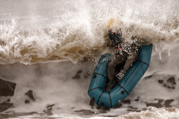After the wave broke, the packraft popped to the surface, upside down.  Moments later Andrew followed and clambered back in.
