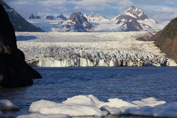 Ice stretches down from the mountains to the lake.  The lake grows, as the ice shrinks.