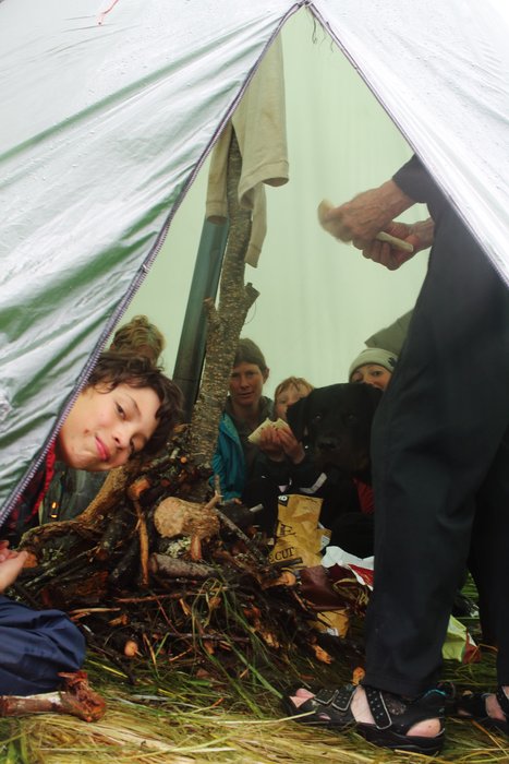 Trail volunteers hiding out in a gear tent warmed by a little titanium wood stove.