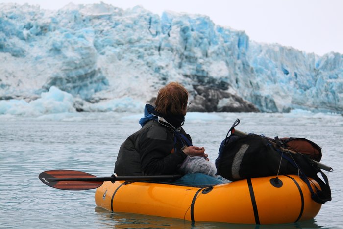 Just after squeezing through the narrow gap <a href="http://www.groundtruthtrekking.org/Journeys/WildCoast.html">between the calving glacier and steep cliff</a>, Hig pauses to eat a gift dropped by a kindly Yakutat pilot.