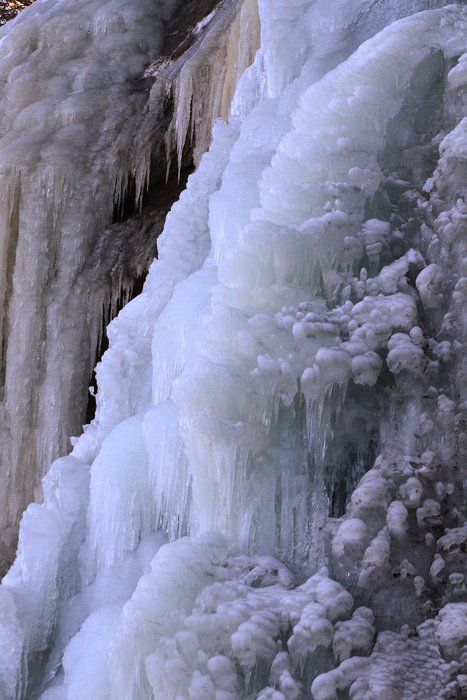 Ice flows over a cliff to the beach on the Seldovia shore