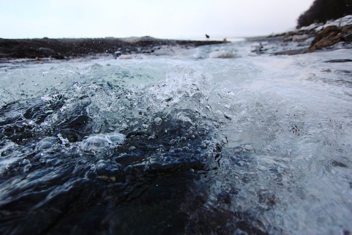 Water boils up from beneath an ice dam into the ocean at the outlet of Barabara Creek