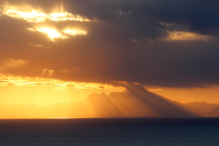 The shadow of Iliamna Volcano stripes the air above Cook Inlet.