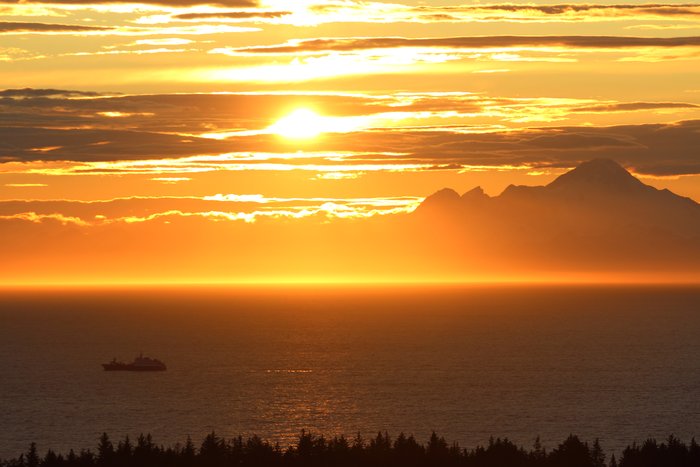 Near solstice the sun sets near Iliamna Volcano.