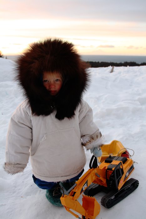 A generous gift from Point Hope, Katmai's parka lets him enjoy his new backhoe on a cold windy day