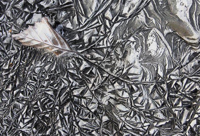 To me it looks like this leaf was captured trying to escape - fingers of ice swirled in from all directions and seized it in an eternal embrace.