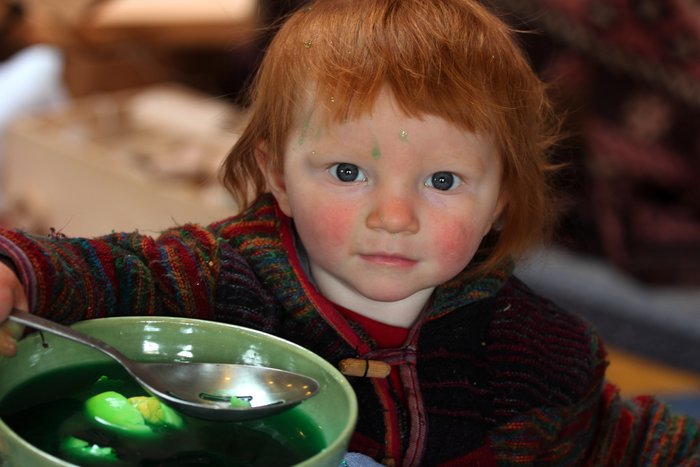 Vigorously. Note the broken egg, and the green dye on her forehead.