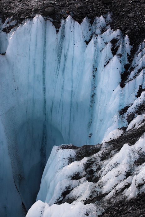 This shaft plunging into the ice reveals that the gravely surface isn't really characteristic of the glacier as a whole.
