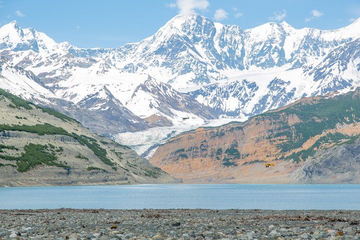 Two Super-Cub airplanes are dwarfed in the foreground in front of Mount Saint Elias, Alaska.