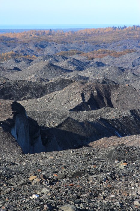 This vista hardly says "glacier" but ice underlies these hills, even to the forest beyond.  The rocks are usually only a few feet thick.  Where they insulate the ice it resists melting until it becomes a hilltop, when it crumbles away and melts all the faster.