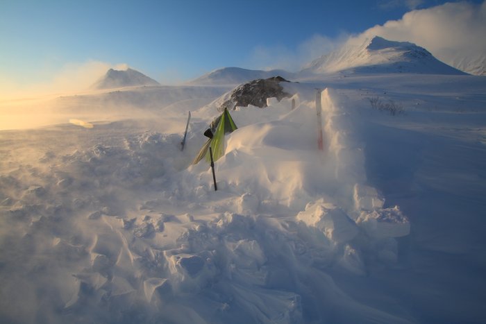 Our snow wall kept back the worst of the windstorm, but blowing snow nearly buried the shelter as we slept.