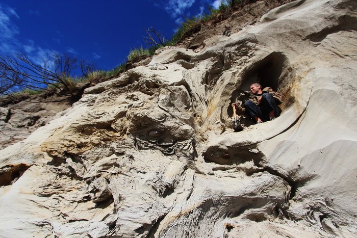 Strange blob-like sedimentary features in this bluff erode out to provide a perch for the troll-like Andrew Mattox.