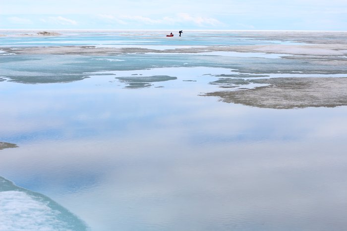 The spring ice held a thin sheen of water, reflecting clouds and ice piles