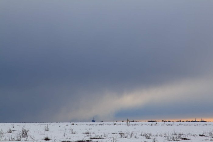 Looking across the marshlands at Controller Bay, an oil rig on Cook Inlet breaks the horizon.