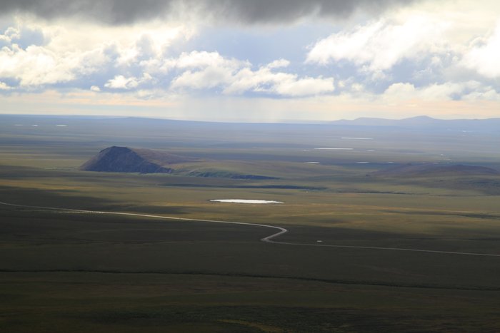 The red dog road winds across the tundra.