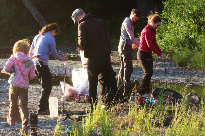 A group of campers works to set up an electric fence to defend their food from bears while they camp.