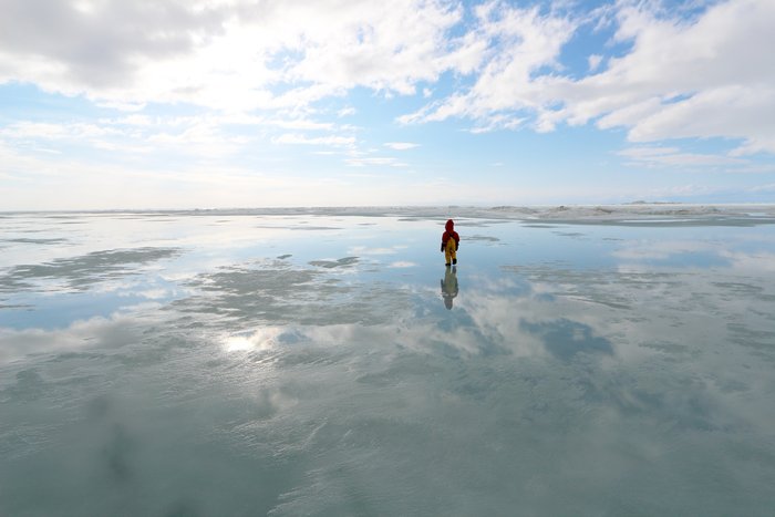 A thin sheen of water on ice sped up our skis, and reflected the sky above us