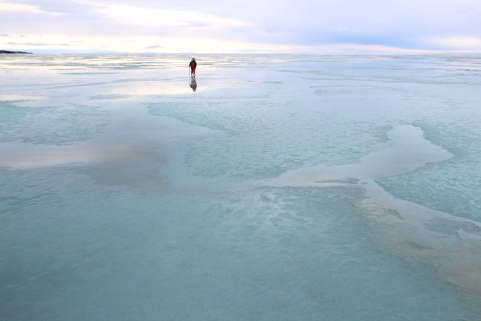 A thin sheen of water on ice sped up our skis, and reflected the sky above us