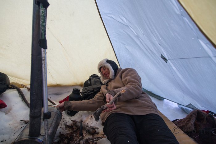Kim feeds alder into the Titanium Goat wood stove.