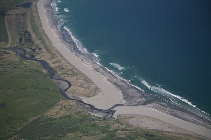 Diverted by beach sand and gravel, this stream winds along behind the beach before making its way seaward.