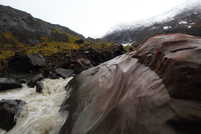Near the head of a valley in the Samovar Hills a large basalt boulder is sculpted by a glacial stream.