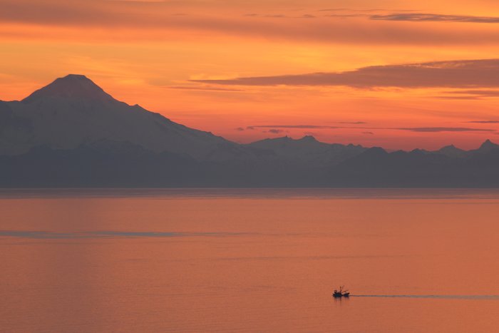 Mt. Iliamna looms above a small fishing boat on Kachemak Bay.