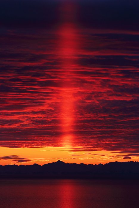 After vanishing behind the mountains, the sun still reflects off the clouds.