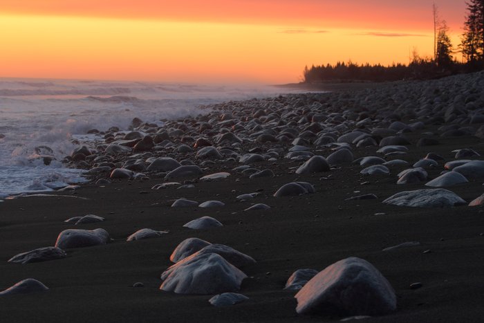 Boulders and sand in the surf of what was once Sitkagi Bluffs.
