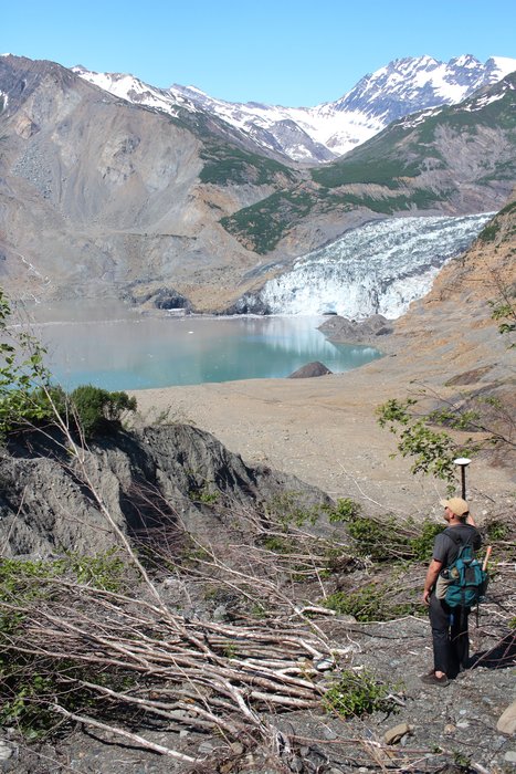 Andrew Mattox carries a Trimble surveying instrument up to the limits of inundation from the 17 Oct 2015 tsunami in Taan Fjord.