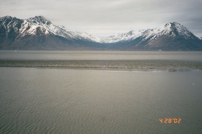 This is the first in a sequence of photos of the April 28 Bore running up the beach.  The Bore is crossing a dry sandbar into a shallow pool near the shore.  This photo looks north across the arm.
