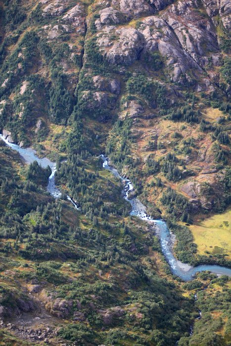 The river descends down through waterfalls - in one case splitting around an island, falling down multiple waterfalls on both sides.