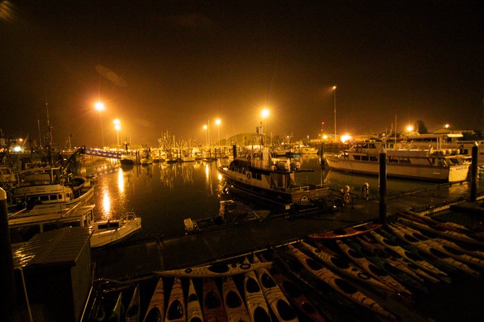 The Valdez boat harbor at night with kayaks in the foreground.