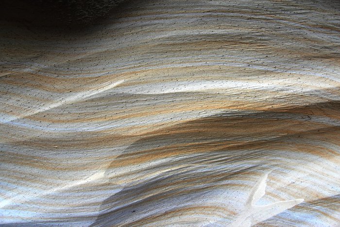 Silty sand colored by iron oxide and eroded by the wind.