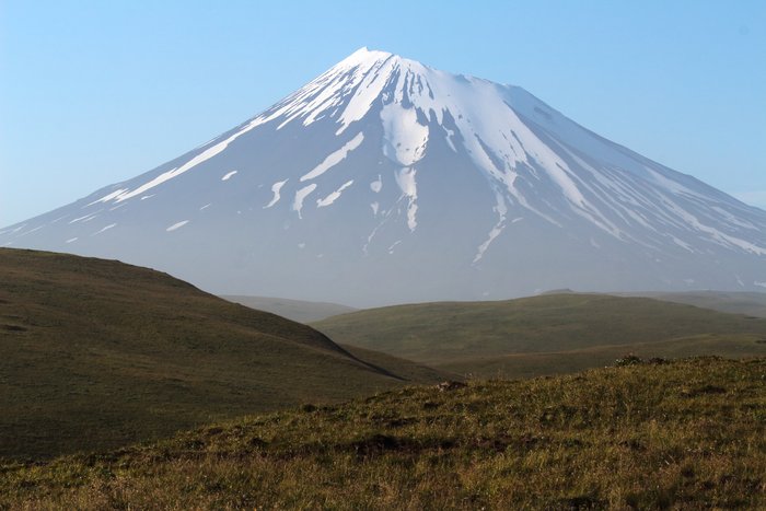 This active volcano rises out of haze from wind-blown volcanic ash on the island of Umnak in the Aleutians.