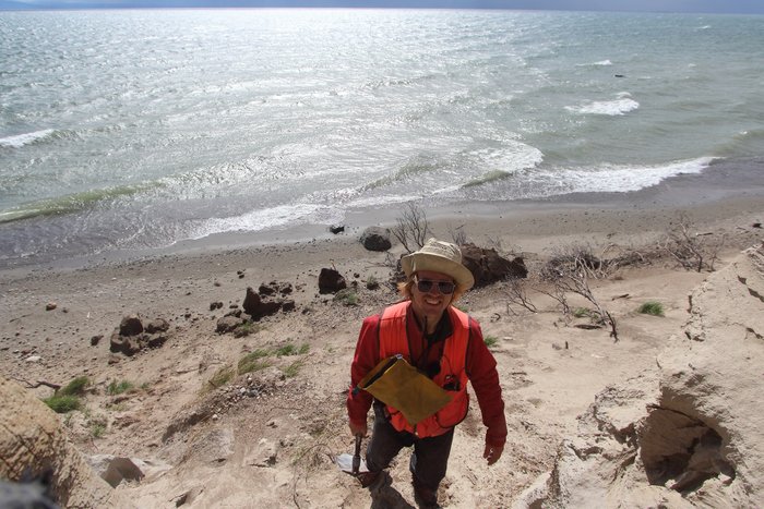 Bretwood Higman doing fieldwork on the shore of Lake Iliamna.